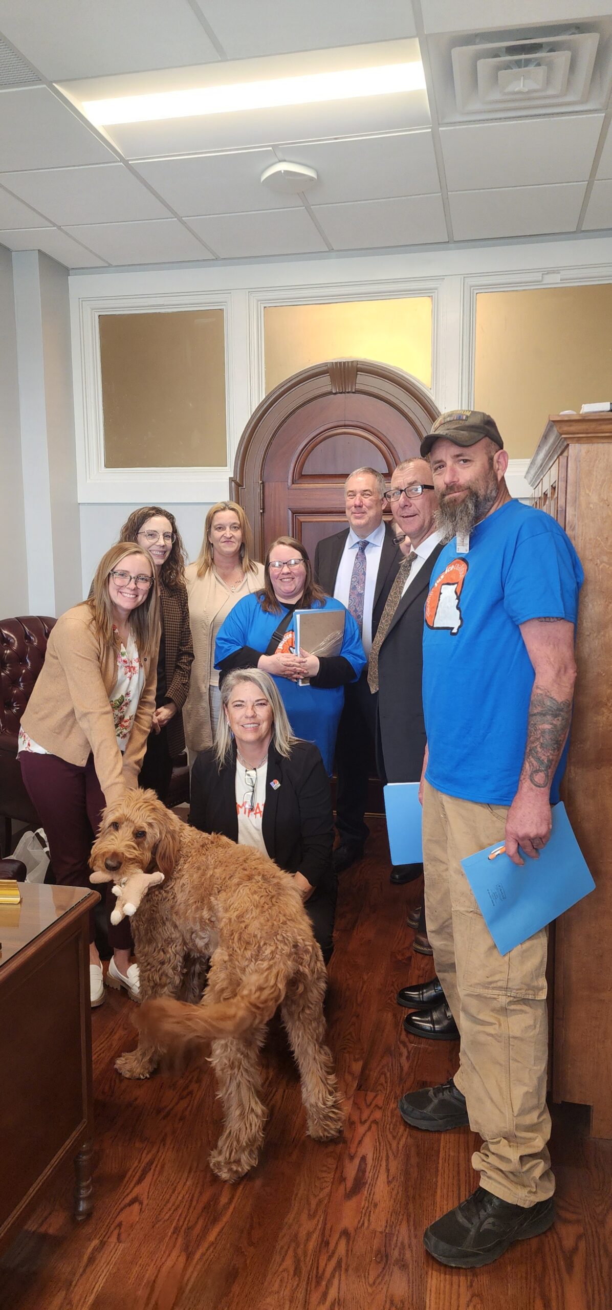 A Group of People Gathered Around a Friendly Dog