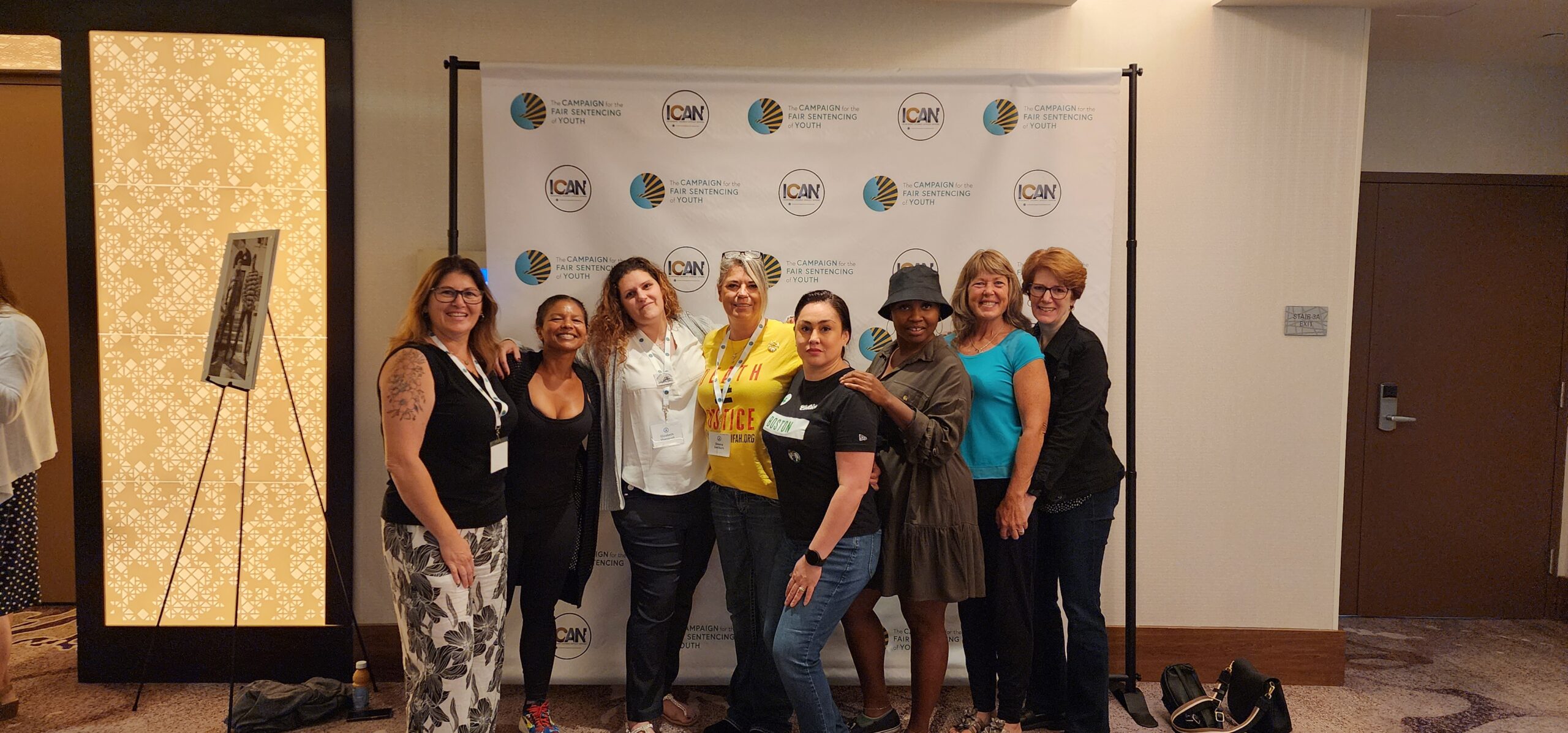 A Group of Women Smiling Together in Front of a Colorful Banner
